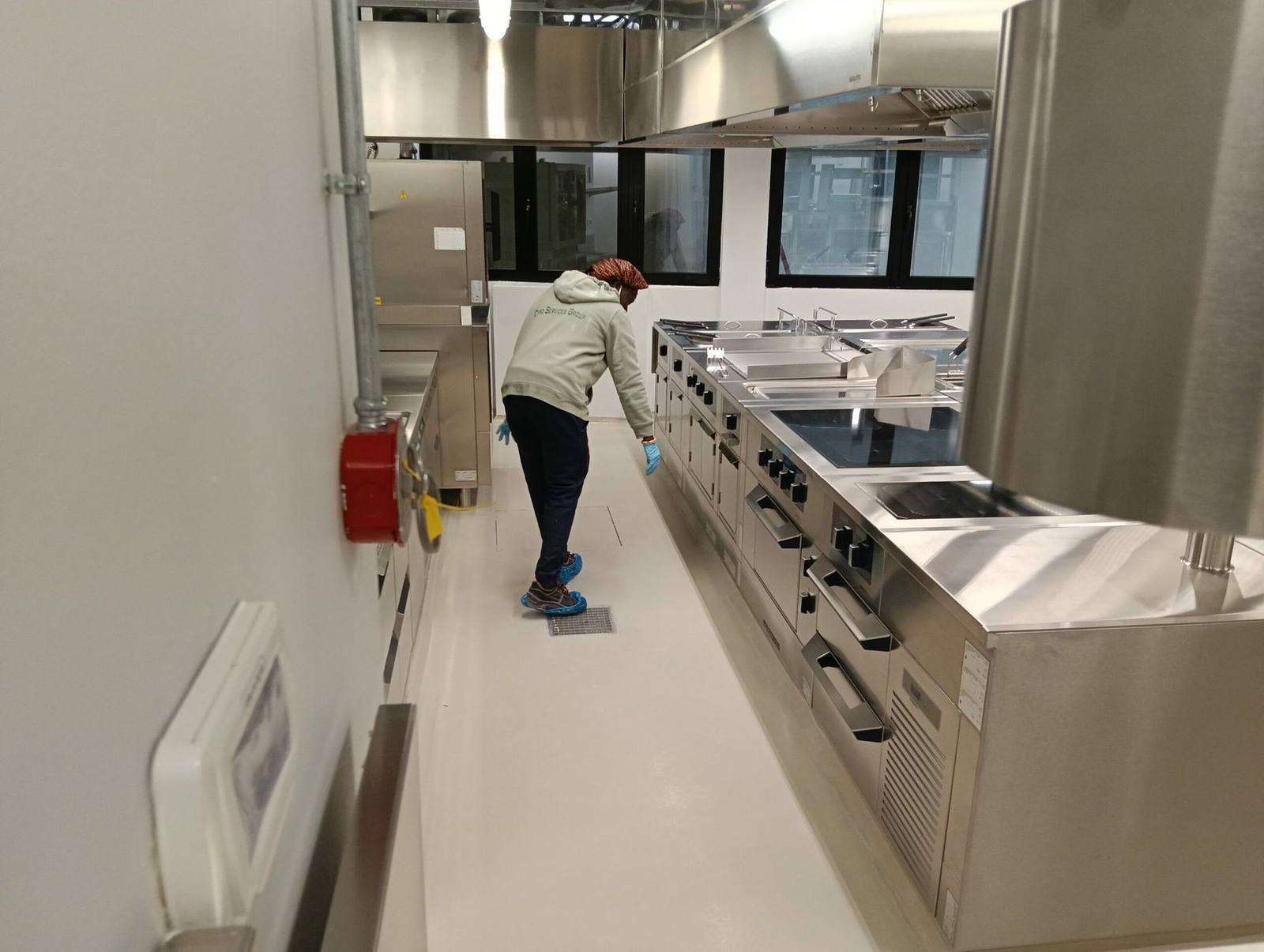 Operatore Cypro Services Group durante la pulizia di una cucina professionale in acciaio