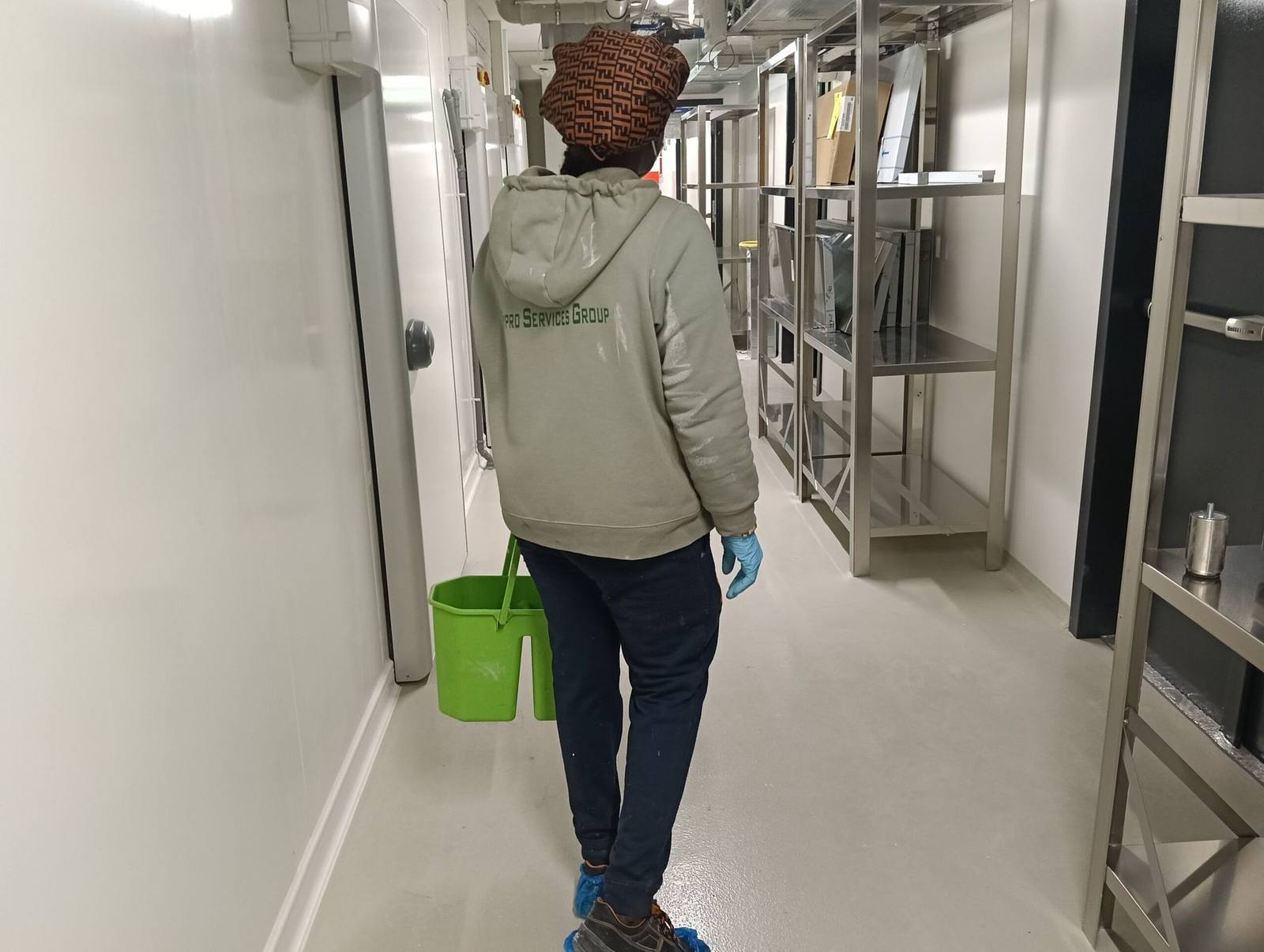 Operatrice Cypro Services Group con il secchio di servizio in un corridoio tecnico